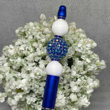 Load image into Gallery viewer, Decorative object with blue and white beads on a floral background
