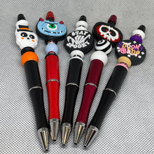Load image into Gallery viewer, Set of novelty pens with unique designs on a textured gray background
