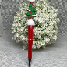 Load image into Gallery viewer, Red pen with a Christmas tree design on top, set against a white floral background.
