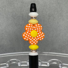 Load image into Gallery viewer, Decorative hair tie with a checkered flower design on a clear stand against a gray background
