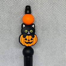 Load image into Gallery viewer, Halloween-themed beadable pen top with black cat and pumpkin design on a textured gray background
