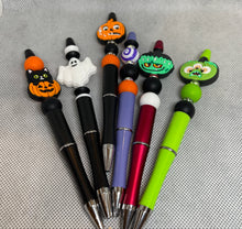 Load image into Gallery viewer, Set of Halloween-themed pens with colorful pen tops on a gray background
