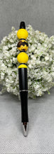 Load image into Gallery viewer, Pen with bee-shaped accents on a white floral background

