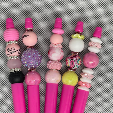 Set of pink and multicolored beaded bookmarks on a textured gray background