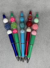 Load image into Gallery viewer, Set of colorful pens with bead accents on a textured surface
