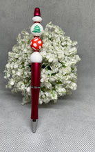 Load image into Gallery viewer, Red pen with white and red polka dot accents on a gray surface with greenery
