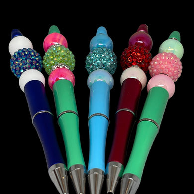Colorful pens with decorative caps on a textured gray background